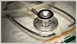 Stethoscope resting on printed medical record sheets